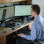 Kai Kloepfer achter zijn rommelige bureau, laat zien hoe zijn vingerafdrukscanner werkt. Foto Hans Klis